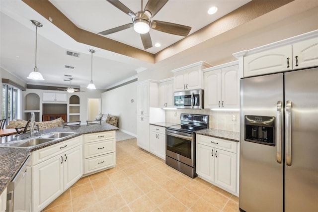 kitchen with sink, appliances with stainless steel finishes, pendant lighting, and white cabinetry