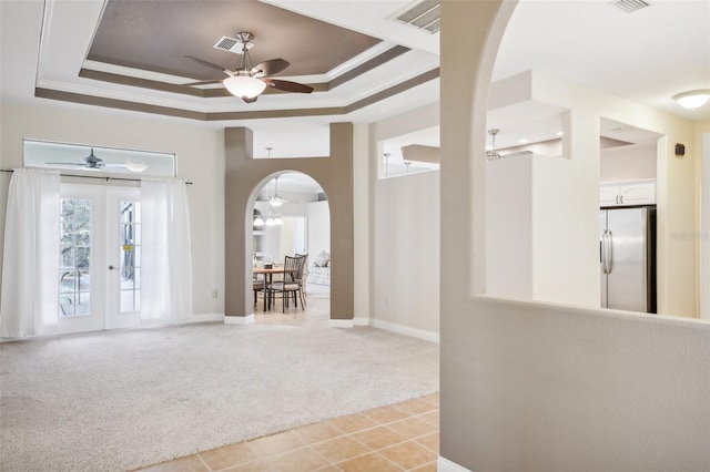 entrance foyer featuring crown molding, french doors, light colored carpet, and a tray ceiling