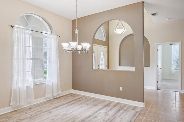 interior space with a notable chandelier and light hardwood / wood-style flooring