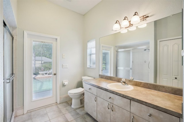 bathroom with vanity, walk in shower, toilet, and tile patterned flooring