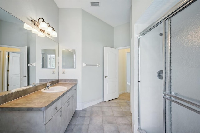 bathroom with vanity, tile patterned floors, and a shower with door