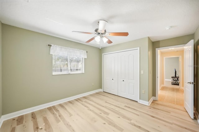 unfurnished bedroom with a closet, a textured ceiling, light hardwood / wood-style floors, and ceiling fan