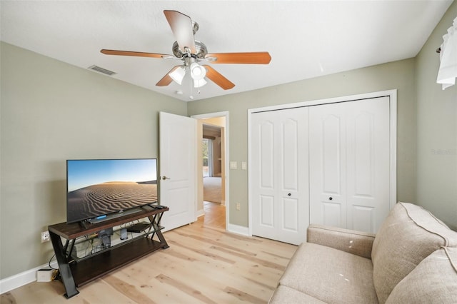 living room featuring light hardwood / wood-style floors and ceiling fan