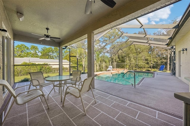 exterior space with ceiling fan, glass enclosure, and a fenced in pool