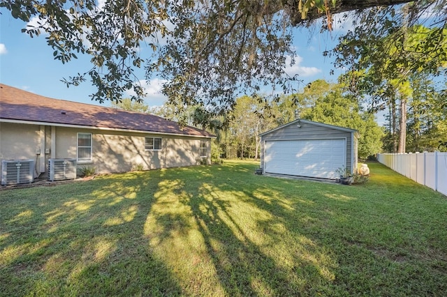 view of yard featuring central AC, a garage, and an outdoor structure