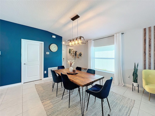 dining area featuring light tile patterned floors, a textured ceiling, and vaulted ceiling