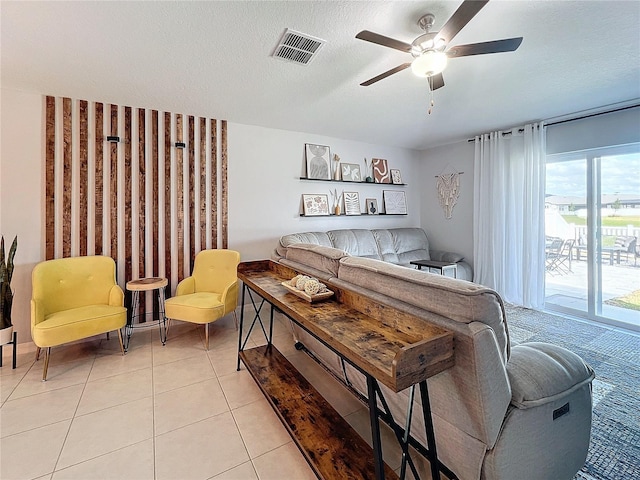 tiled living room featuring ceiling fan and a textured ceiling