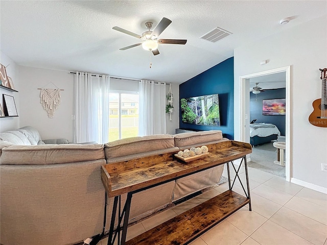 tiled living room with ceiling fan, a textured ceiling, and vaulted ceiling