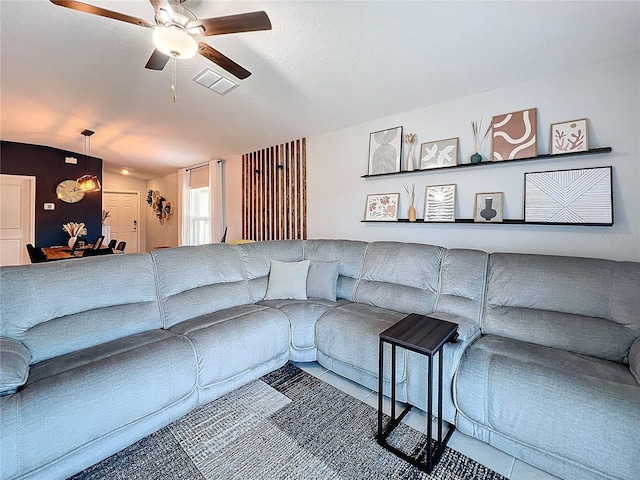 living room with ceiling fan and vaulted ceiling