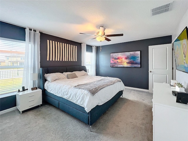 carpeted bedroom with a textured ceiling and ceiling fan