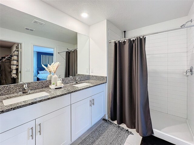 bathroom with tile patterned flooring, vanity, a textured ceiling, and a shower with shower curtain