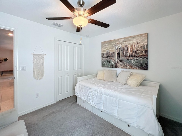 carpeted bedroom featuring ceiling fan and a closet