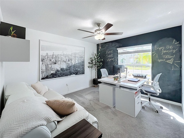 carpeted office space featuring ceiling fan and a textured ceiling