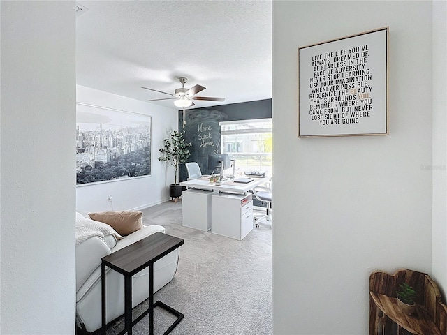 living room with a textured ceiling, light colored carpet, and ceiling fan