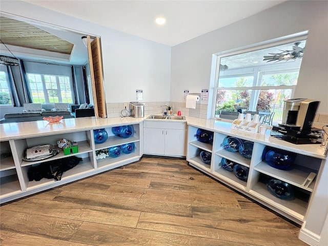 kitchen with wood-type flooring, white cabinetry, a wealth of natural light, and ceiling fan