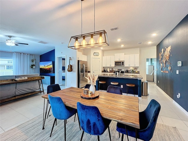 dining space featuring light tile patterned floors and ceiling fan