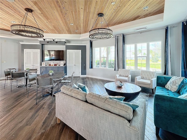 living room featuring a wealth of natural light, hardwood / wood-style floors, and an inviting chandelier