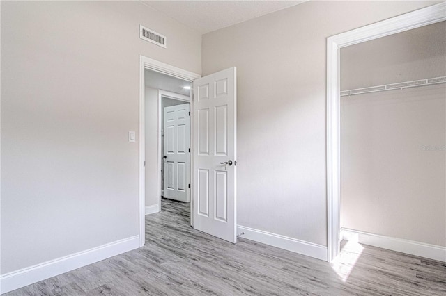 unfurnished bedroom featuring light wood-type flooring and a closet