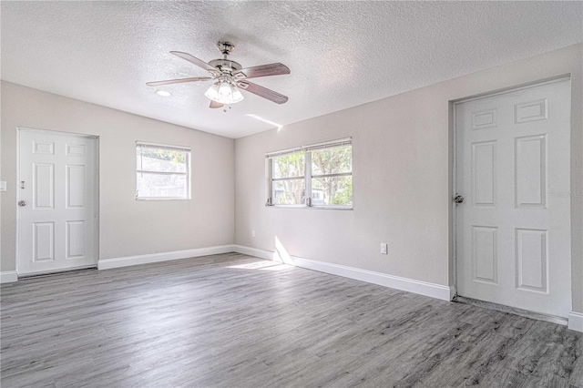 unfurnished room with wood-type flooring, ceiling fan, and a textured ceiling