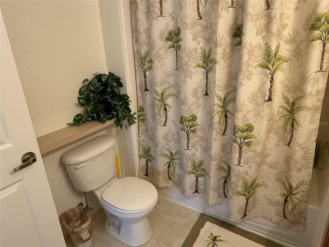 bathroom with toilet, tile patterned flooring, and shower / tub combo