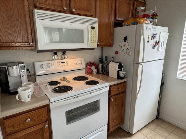 kitchen with light tile patterned floors and white appliances