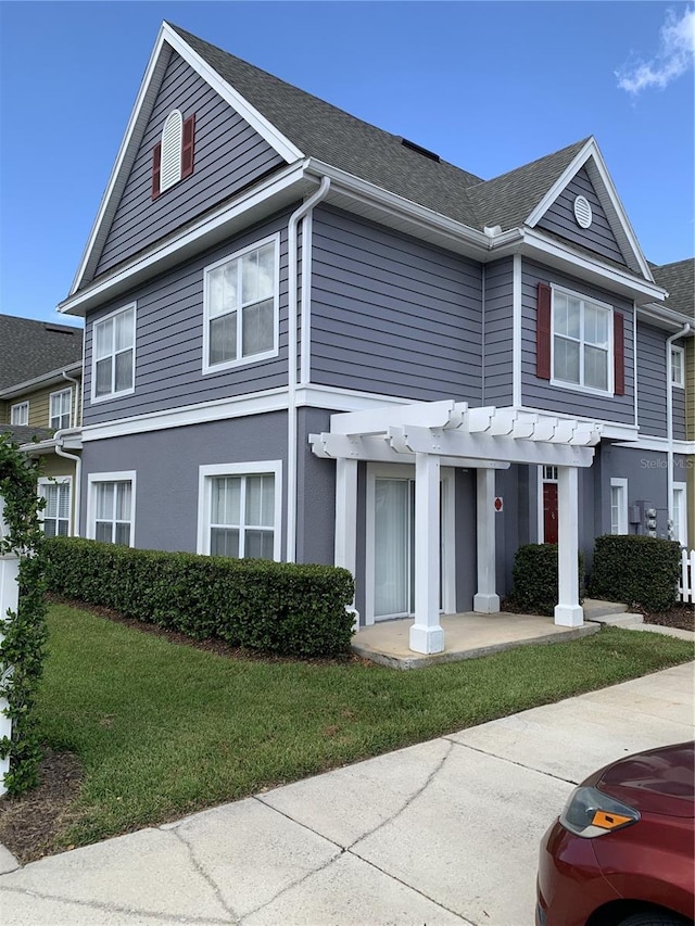 view of front of home featuring a pergola and a front lawn