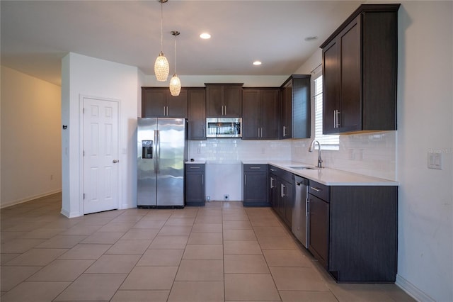 kitchen featuring dark brown cabinets, stainless steel appliances, sink, pendant lighting, and tasteful backsplash