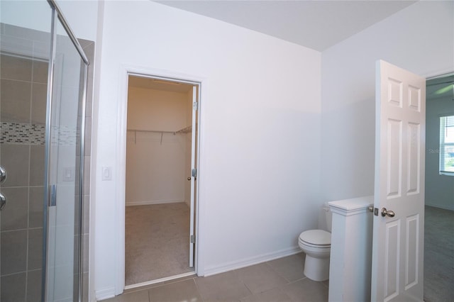 bathroom with tile patterned flooring, toilet, and walk in shower