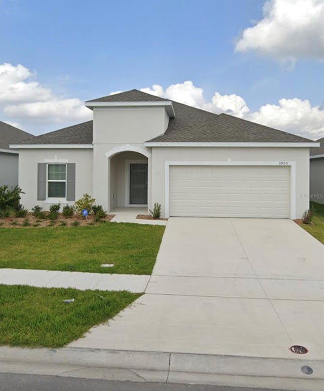 view of front facade featuring a front lawn and a garage