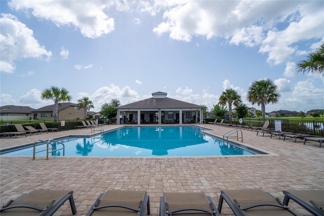 view of pool featuring a patio and a water view