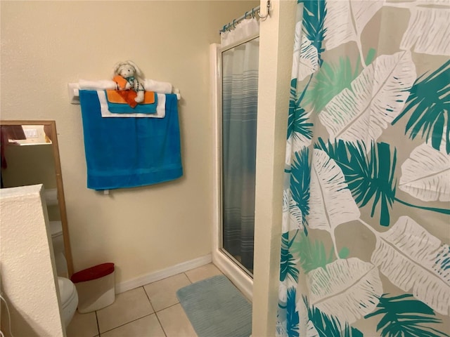 bathroom featuring toilet, tile patterned floors, and walk in shower