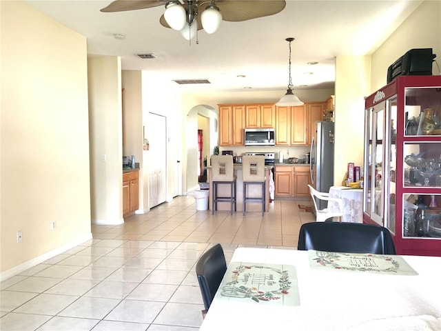 tiled dining area with ceiling fan