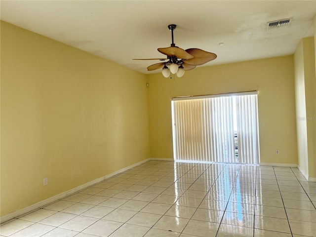 spare room featuring light tile patterned floors, baseboards, visible vents, and ceiling fan