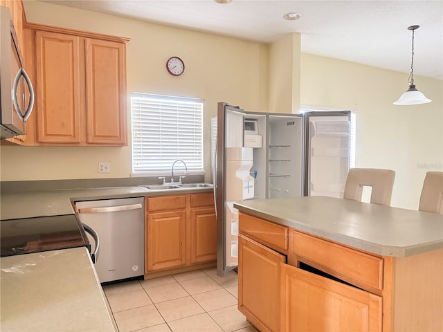 kitchen featuring light tile patterned floors, stainless steel appliances, a sink, hanging light fixtures, and light countertops