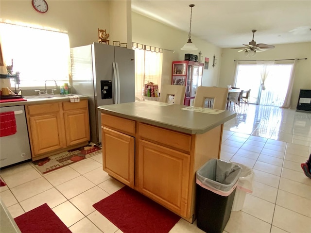 kitchen featuring a kitchen island, appliances with stainless steel finishes, light countertops, pendant lighting, and light tile patterned flooring