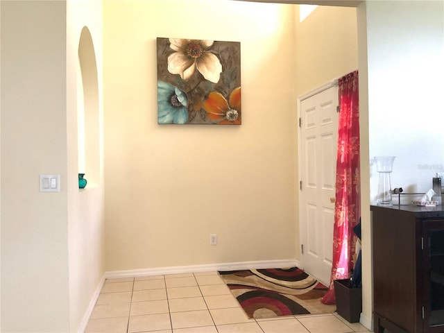 foyer entrance with baseboards and light tile patterned floors