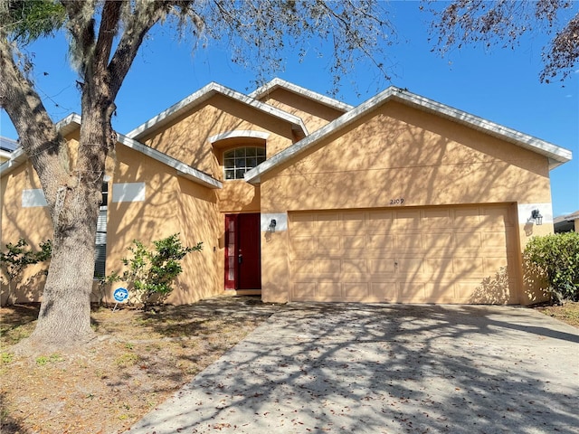 view of front of house featuring driveway, an attached garage, and stucco siding