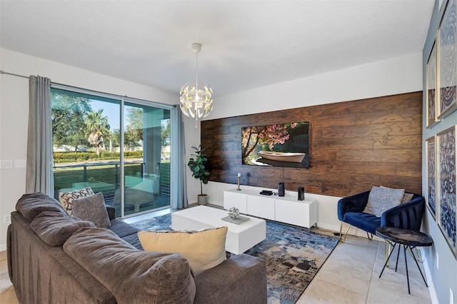 tiled living room featuring wood walls, a chandelier, and a textured ceiling