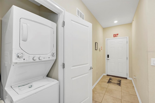 washroom with light tile patterned flooring and stacked washer and clothes dryer