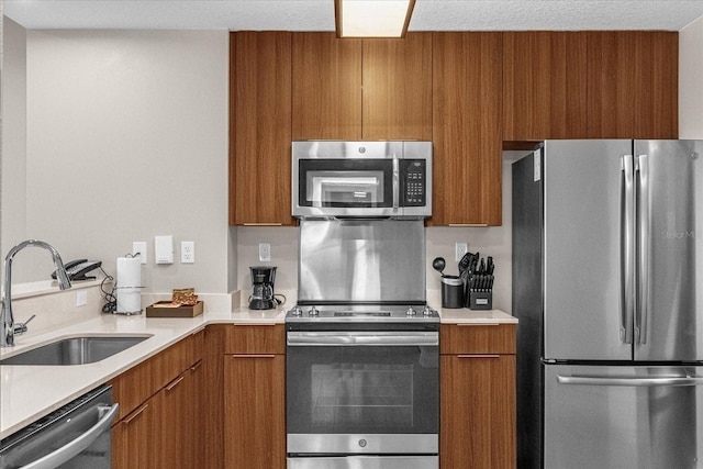 kitchen featuring sink, appliances with stainless steel finishes, and a textured ceiling