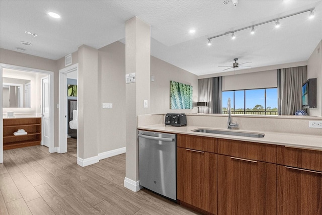 kitchen featuring light hardwood / wood-style flooring, sink, stainless steel dishwasher, a textured ceiling, and ceiling fan