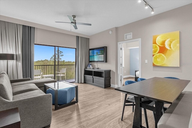 living room featuring light hardwood / wood-style flooring, rail lighting, and ceiling fan