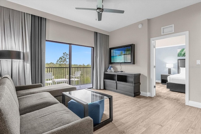 living room with light hardwood / wood-style floors and ceiling fan