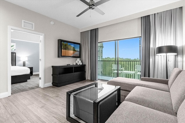 living room with ceiling fan and light wood-type flooring