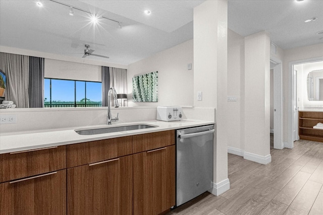 kitchen featuring light wood-type flooring, sink, stainless steel dishwasher, and ceiling fan