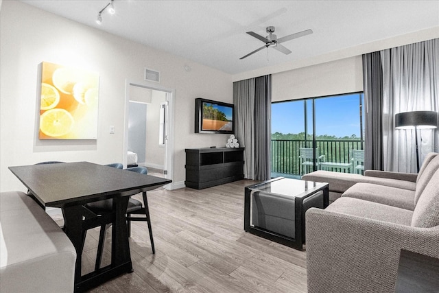 living room with light hardwood / wood-style flooring and ceiling fan