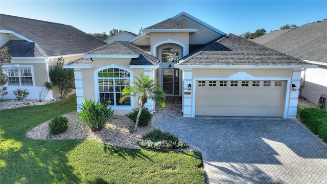 front facade featuring a front lawn and a garage