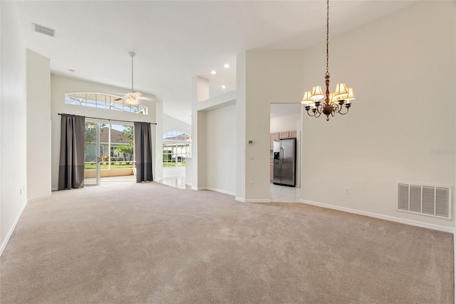 unfurnished room with ceiling fan with notable chandelier, light colored carpet, and high vaulted ceiling