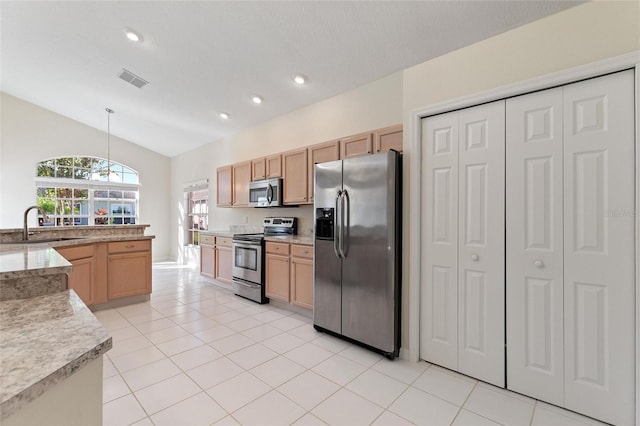 kitchen featuring light brown cabinetry, vaulted ceiling, sink, pendant lighting, and stainless steel appliances