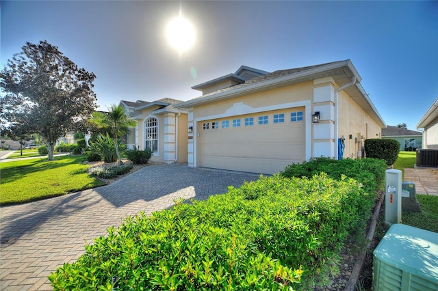 view of front of property featuring a front yard, cooling unit, and a garage